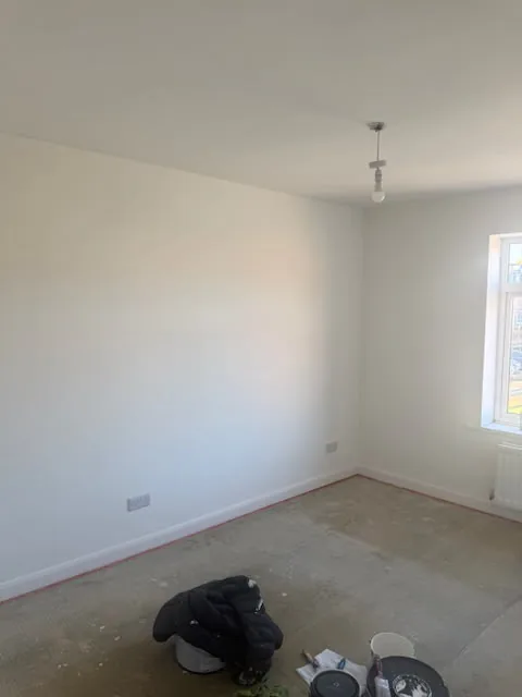 Large double bedroom painted white, ready for flooring