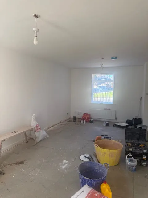 Freshly plastered living room with tools on the floor