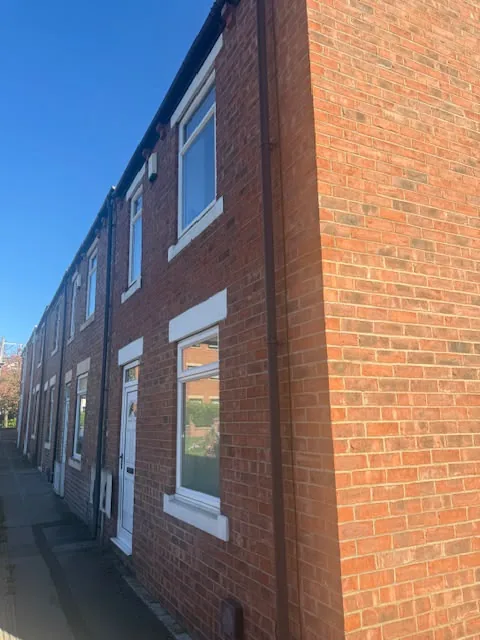 Outside view of a red-brick terraced house in the North East